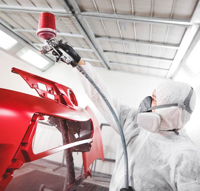 I-CAR Gold Class certified technician painting vehicle